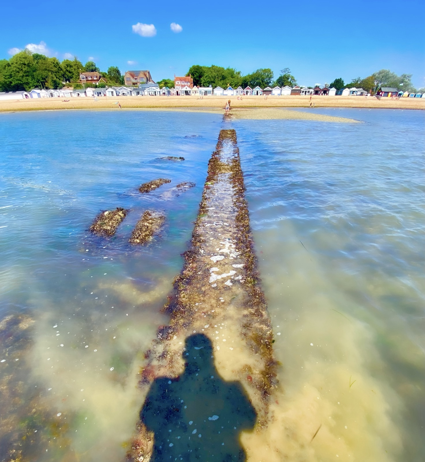 Calshot Beach, Hampshire, UK on a summer day, with blue water and light yellow sand