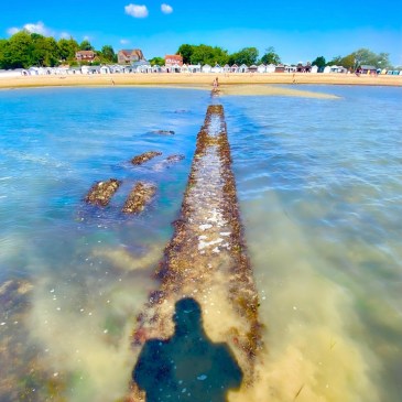Calshot Beach, Hampshire, UK on a summer day, with blue water and light yellow sand